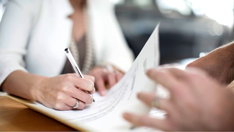 image of a woman signing paperwork