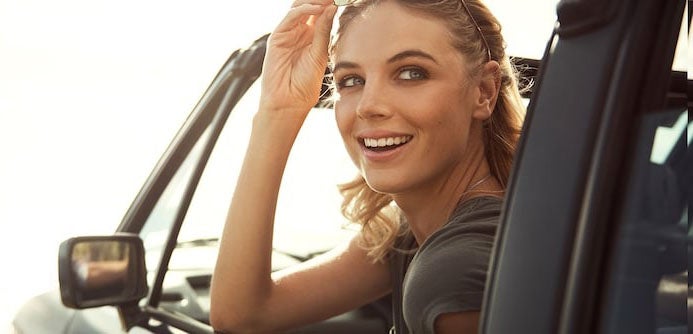 image of a woman in a convertable looking out of the driver's side